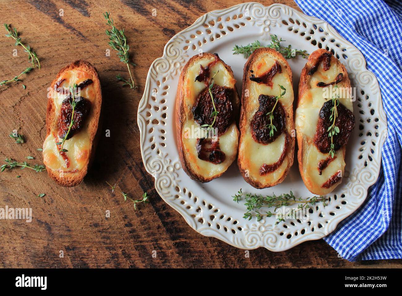 Bruschetta with mozzarella, sundried tomatoes and thyme Stock Photo