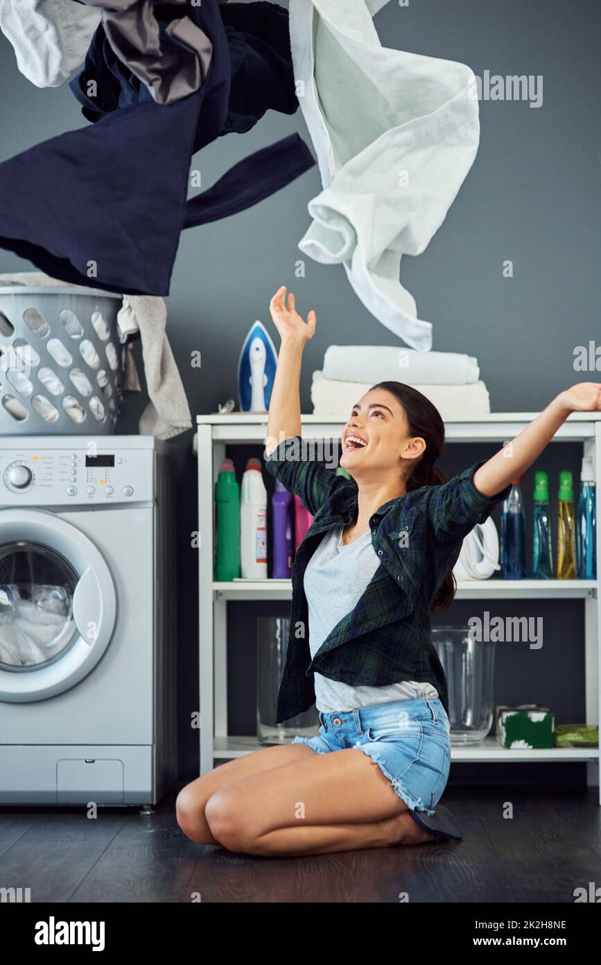 Its laundry day. Full length shot of an attractive young woman throwing her washing in the air