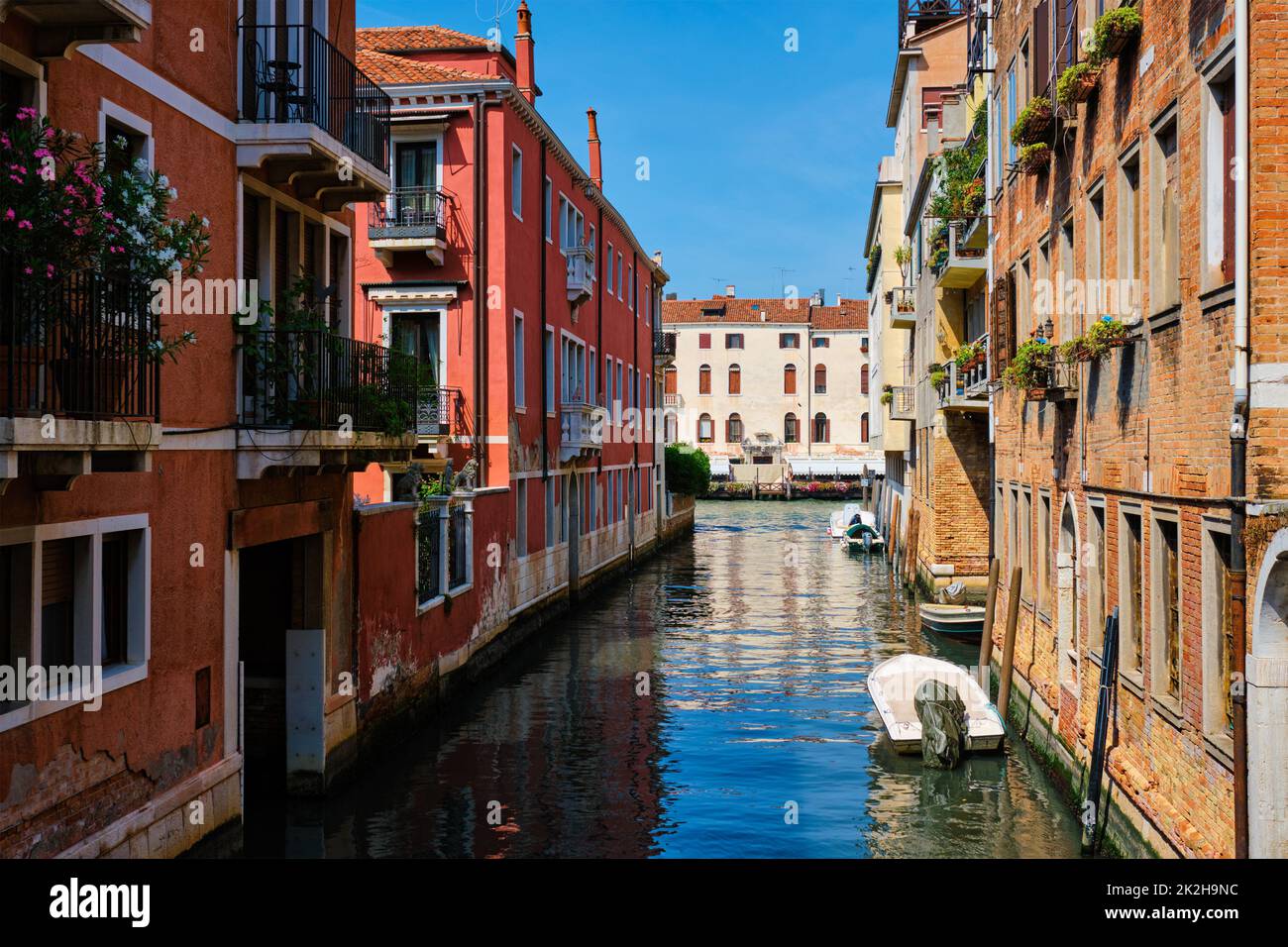 Narrow canal with gondola in Venice, Italy Stock Photo