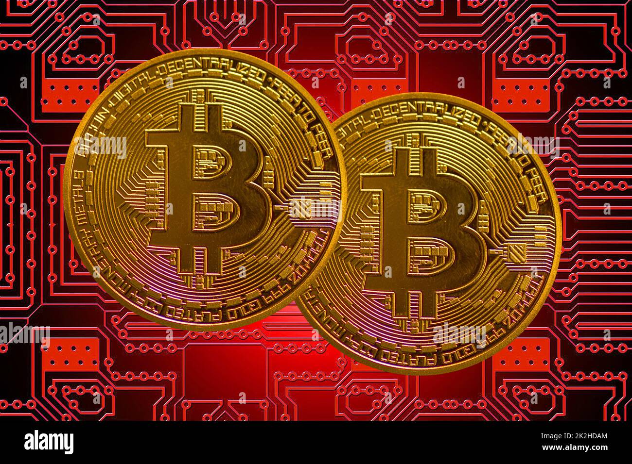 two golden valueabl bitcoin from crypto currency with a red board in the back Stock Photo