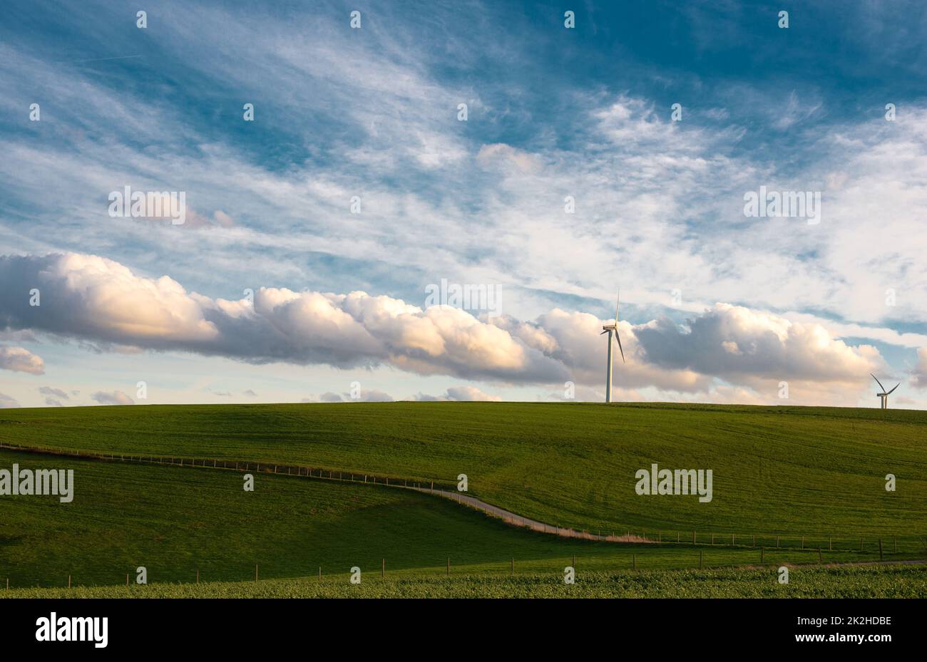 Stormy weather in the spring, clouds in the sky, green meadow, agriculture in Germany, landscape, wind energy and environment discussion, countryside scene Stock Photo