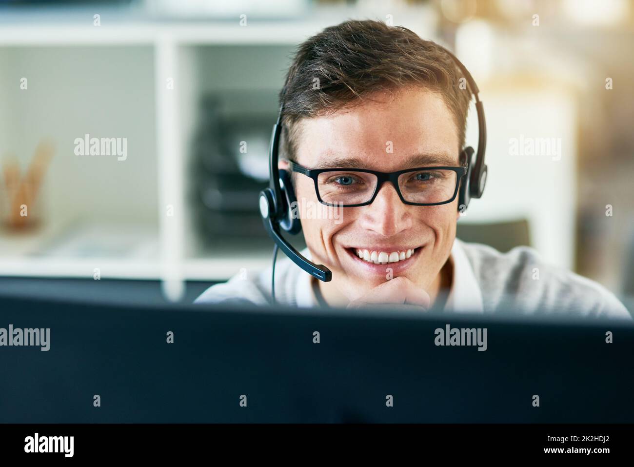 Handling every call with seamless professionalism. Shot of a young call center agent working in an office. Stock Photo