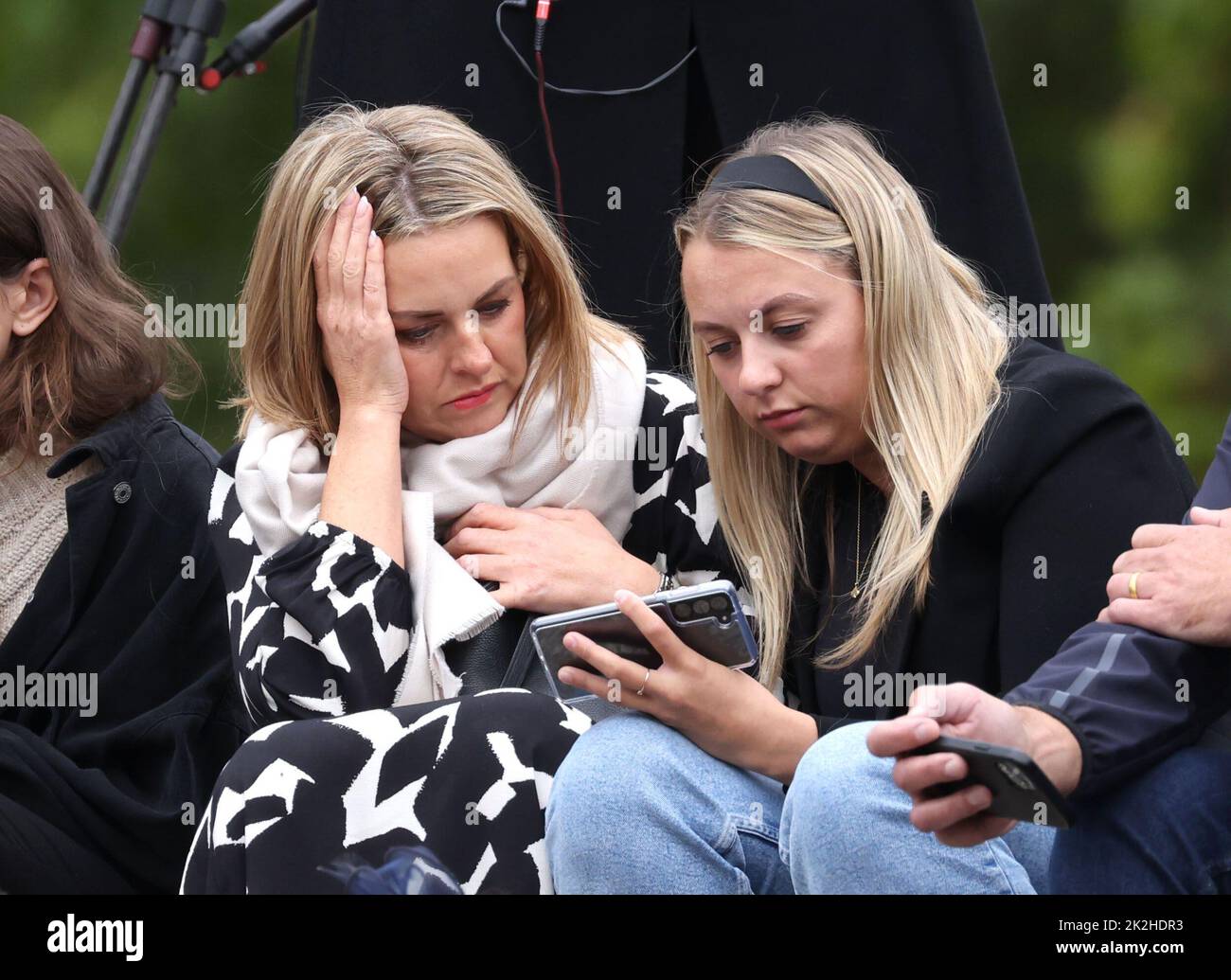 People watch the television coverage on their mobile phones. The State