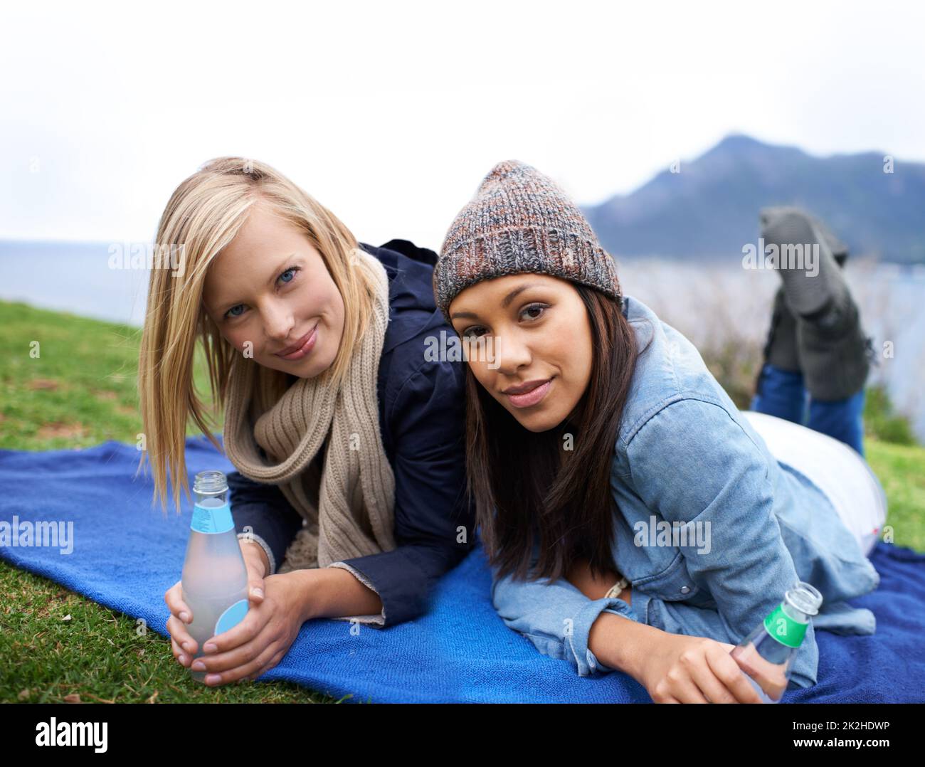 Leisure time with my best friend. Two young women smiling while lying on the lawn outside. Stock Photo