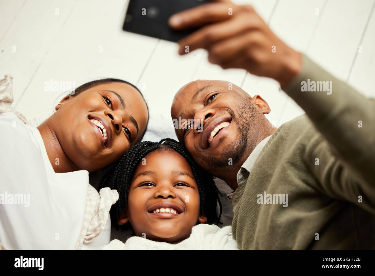 Capturing every memory. Shot of a young family taking a selfie at home. Stock Photo