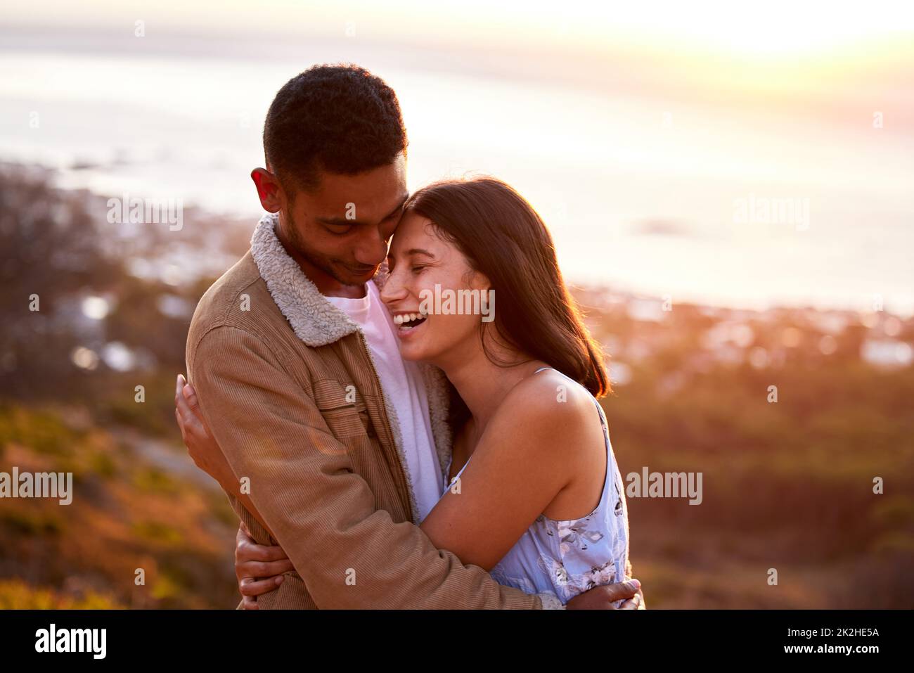 Nowhere else Id rather be. Cropped shot of an affectionate young couple embracing lovingly at sunset. Stock Photo