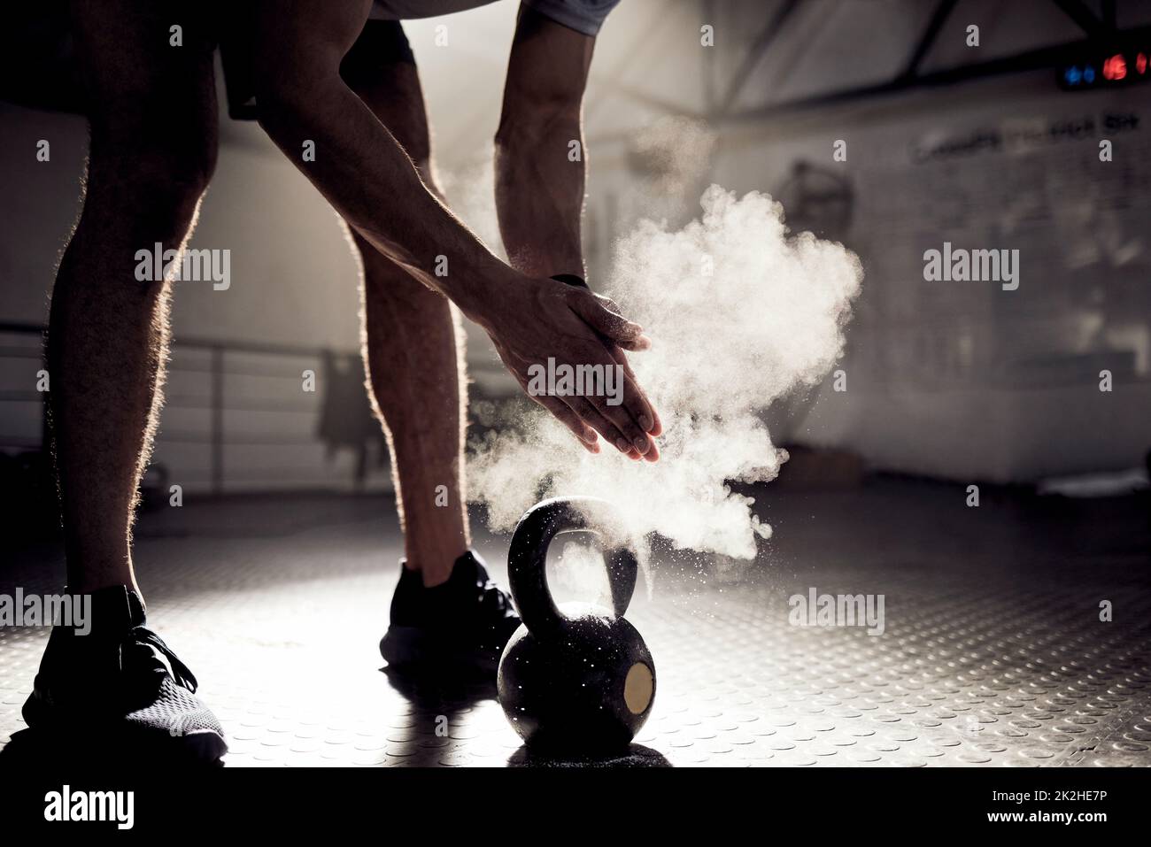 Dont go through life obsessing about what might have been. Shot of an unrecognisable man rubbing sports chalk on his hands while exercising with a kettlebell in a gym. Stock Photo