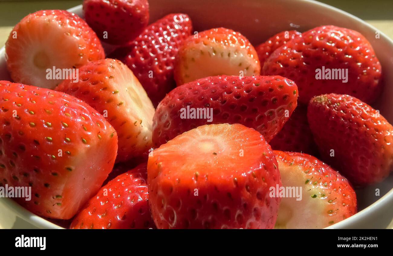 Fresh strawberries are poured into a white bowl Stock Photo - Alamy
