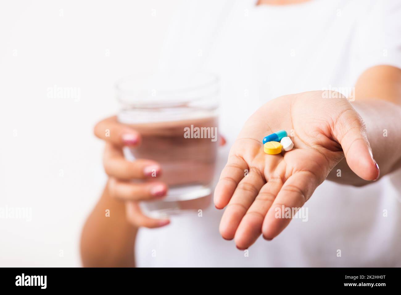 Woman hold pill drugs in hand ready take medicines with a glass of