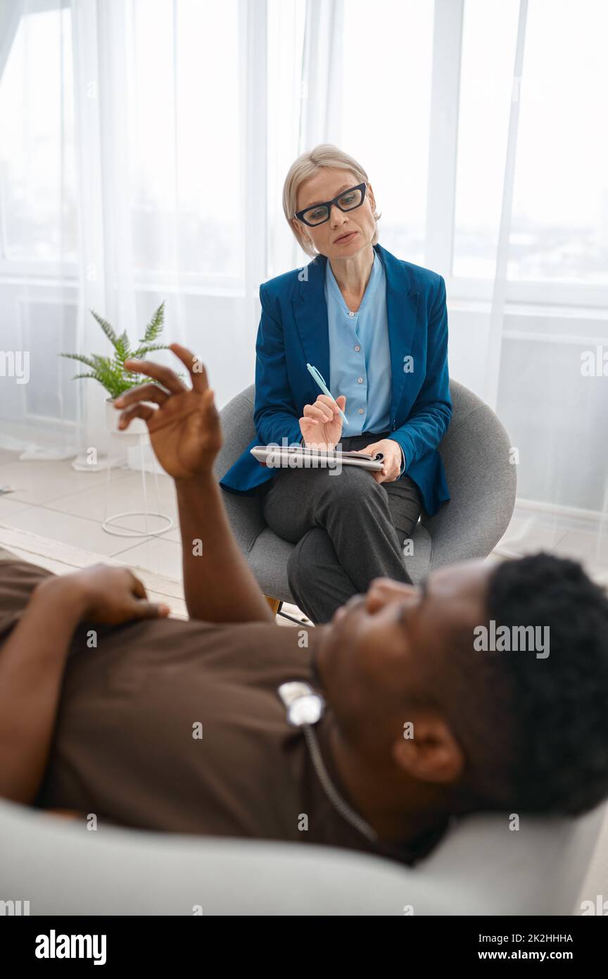 Psychologist making notes while male soldier talking Stock Photo