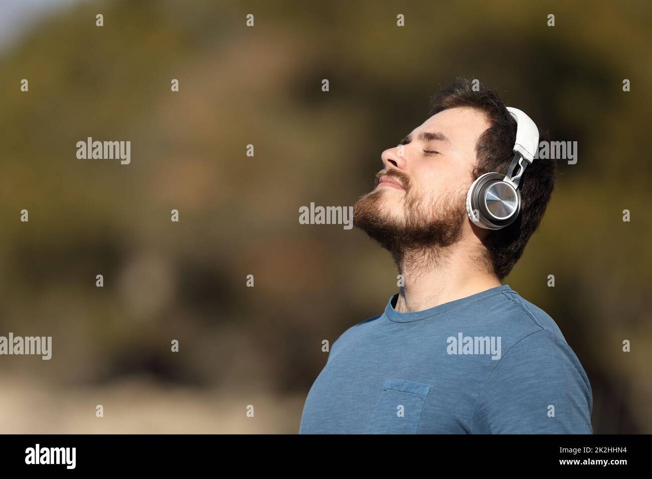 Man meditating with headphones in nature Stock Photo