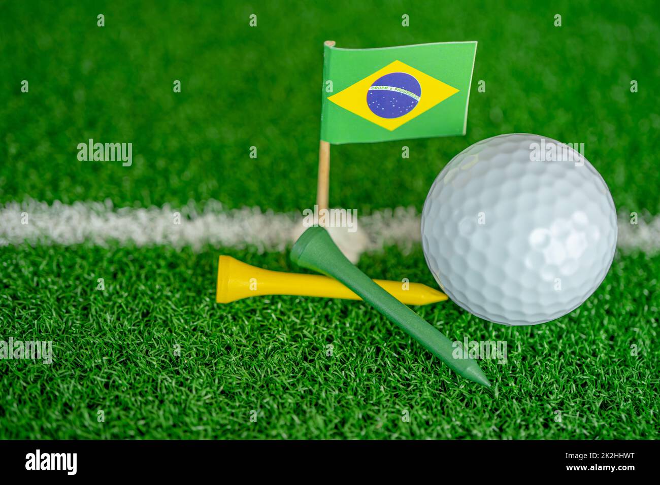 Golf ball with Brazil flag and tee on green lawn or grass is most