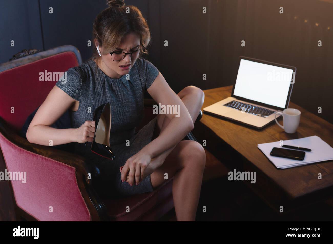 Business woman with aching feet after long working day of wearing high