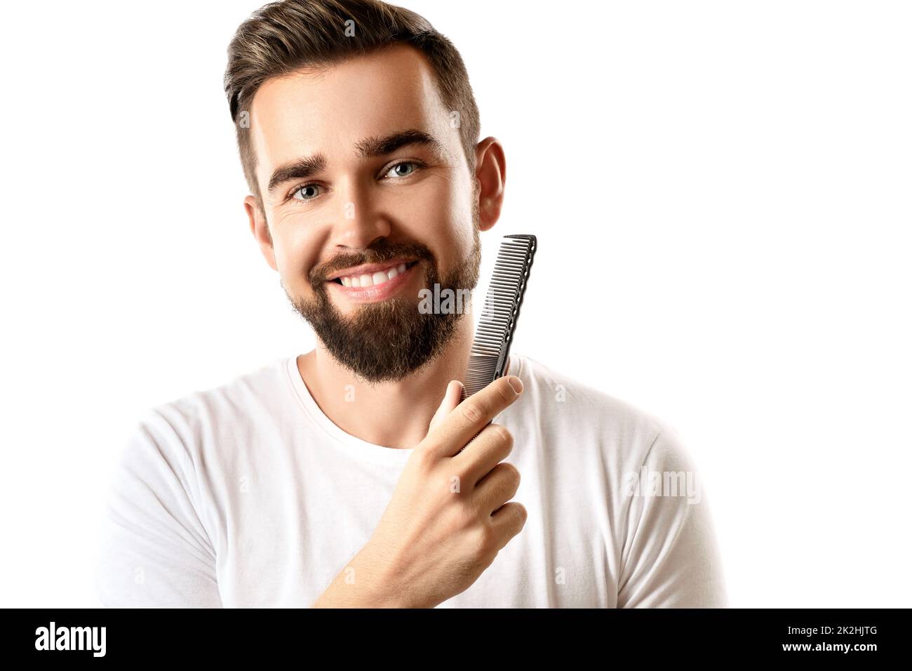 Handsome well groomed man combing his beard Stock Photo