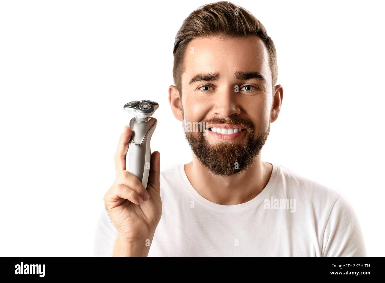 Handsome bearded man holding electric shaver in his hand Stock Photo