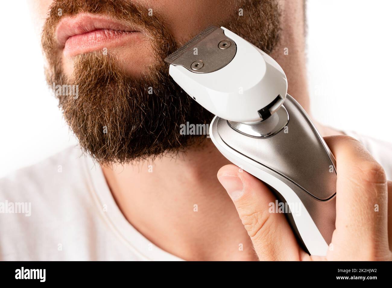 Handsome bearded man is using electric trimmer Stock Photo