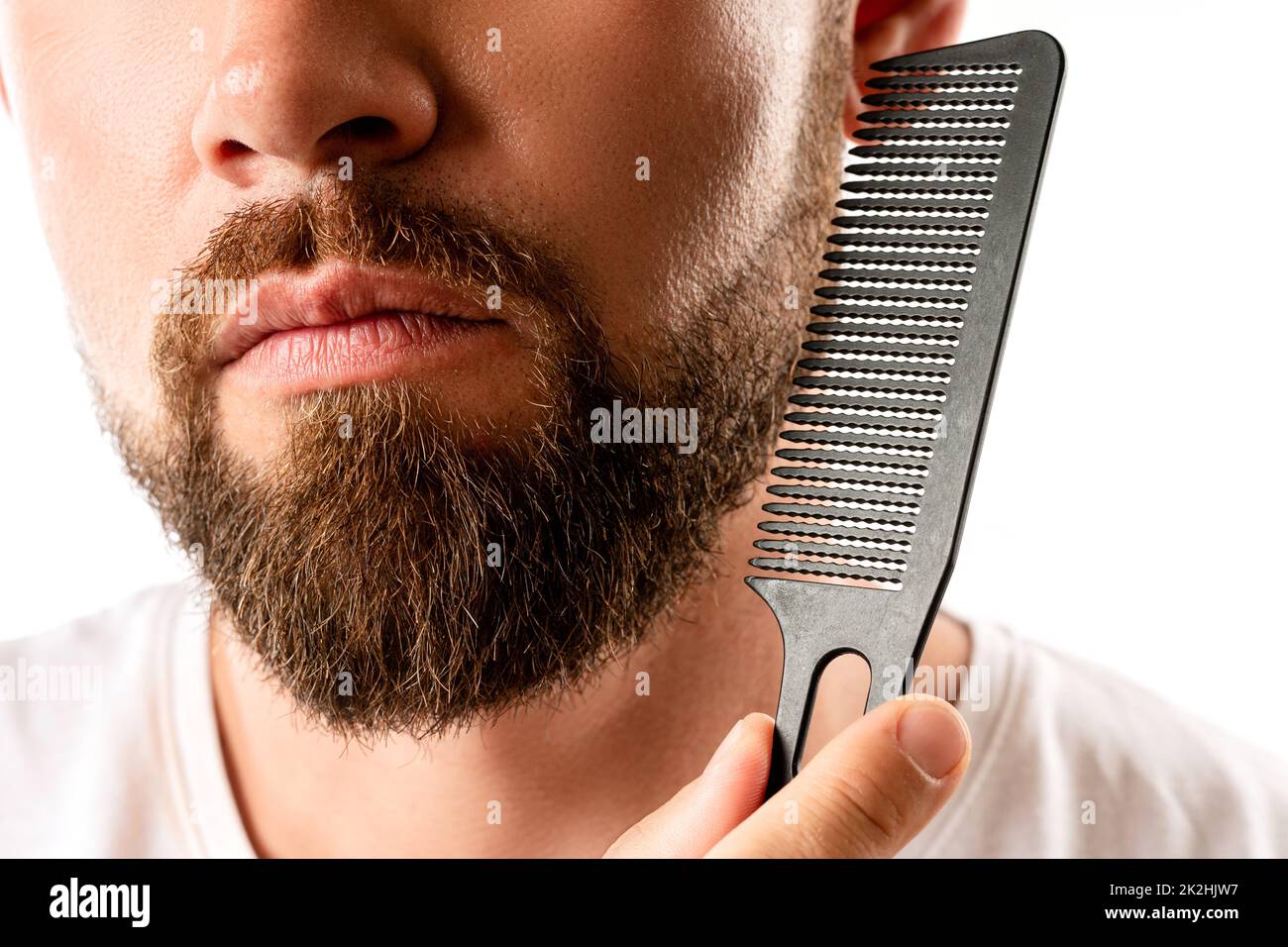 Well groomed man combing his beard Stock Photo