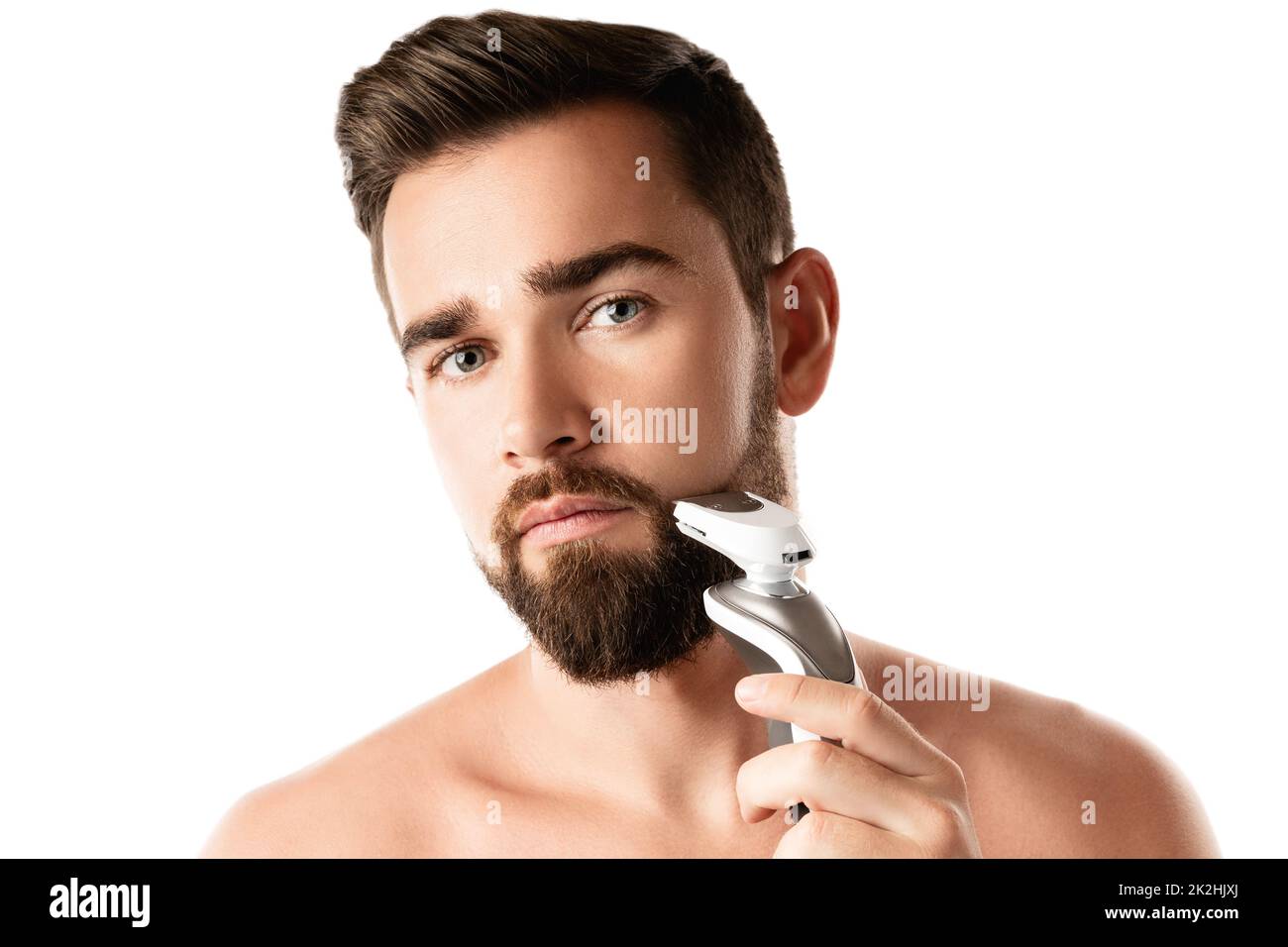 Handsome bearded man is using electric trimmer Stock Photo