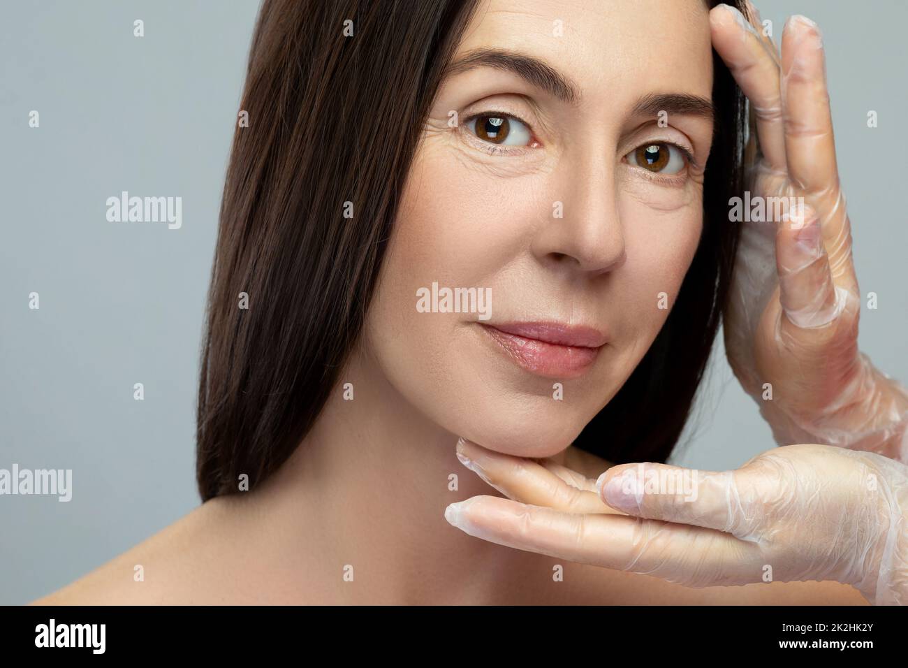 Middle aged woman receiving examination by professional beautician. Stock Photo