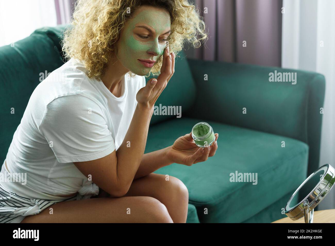 Beautiful woman is applying exfoliating and  cleansing mask Stock Photo