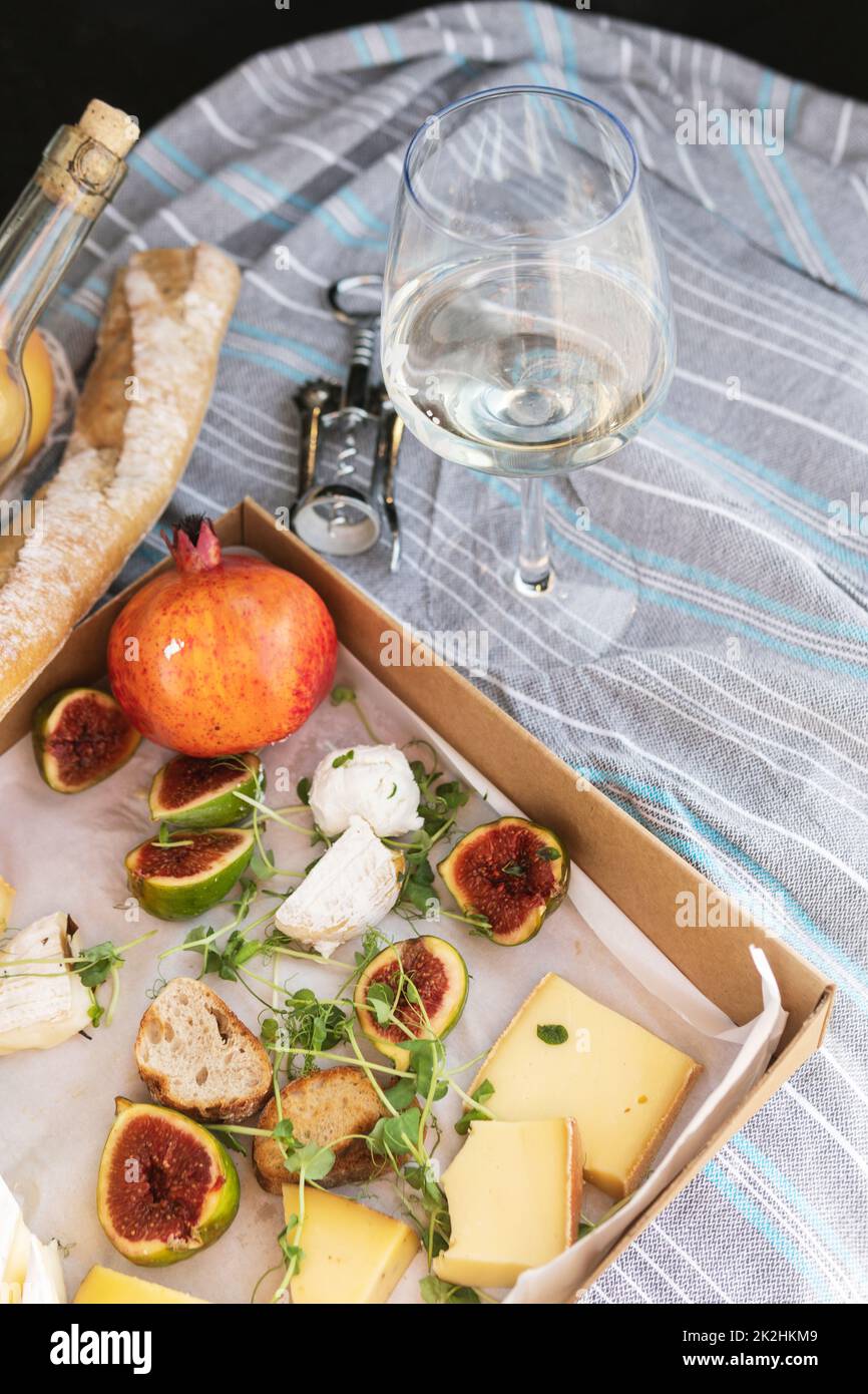 Different delicious food and glass of wine on picnic. Stock Photo