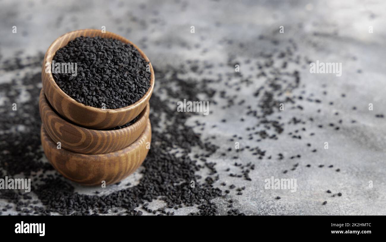 Indian spice Black cumin (nigella sativa or kalonji) seeds in wooden bowls close up Stock Photo