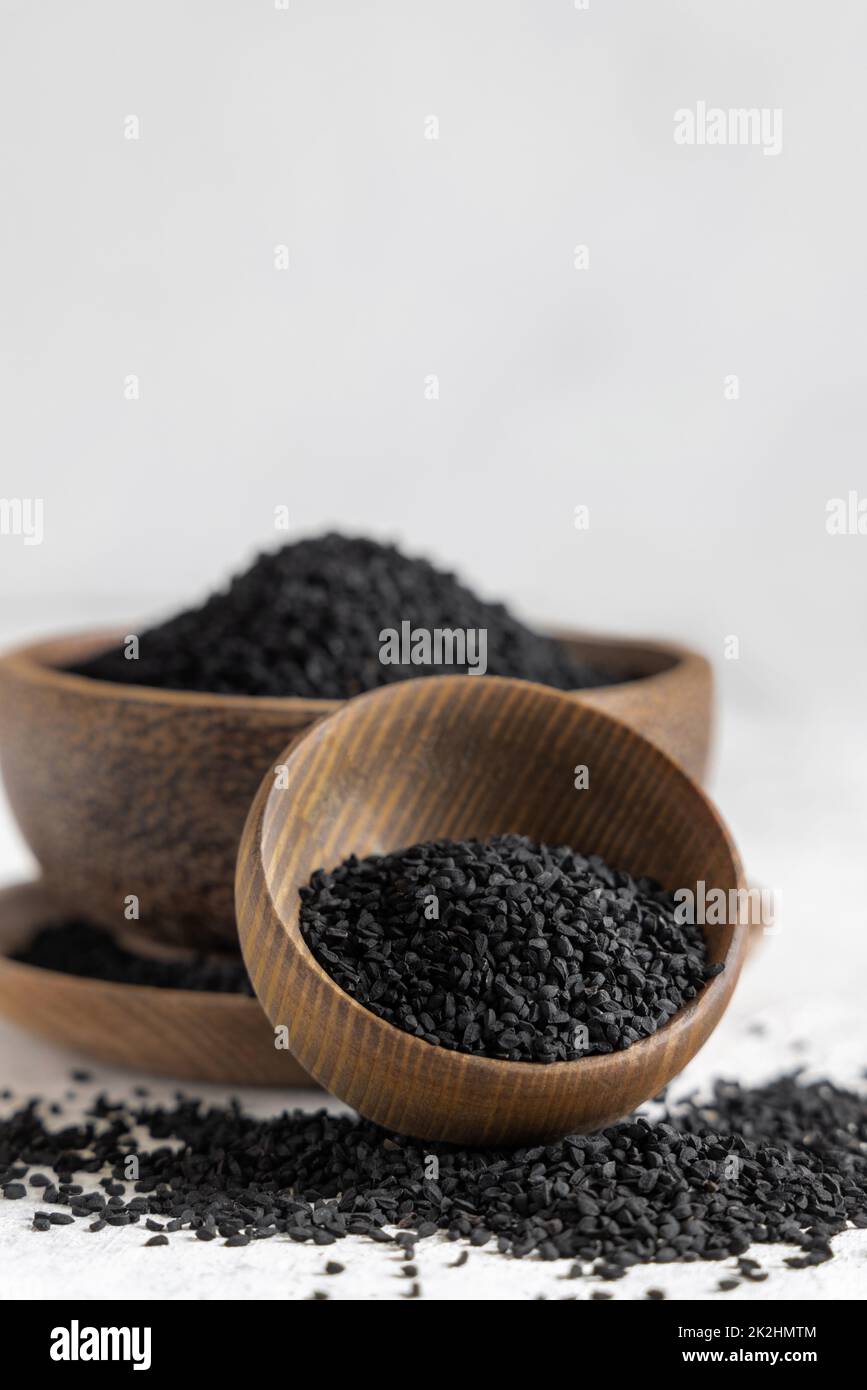 Indian spice Black cumin (nigella sativa or kalonji) seeds in wooden bowls close up Stock Photo