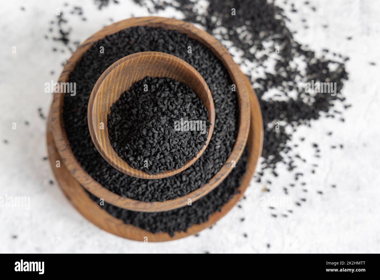 Indian spice Black cumin (nigella sativa or kalonji) seeds in wooden bowls top view Stock Photo