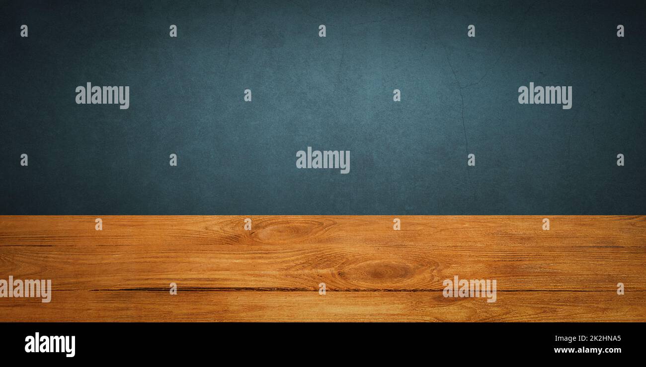 The background is blank wooden boards and a textured plastered wall with lighting and vignetting. Stock Photo