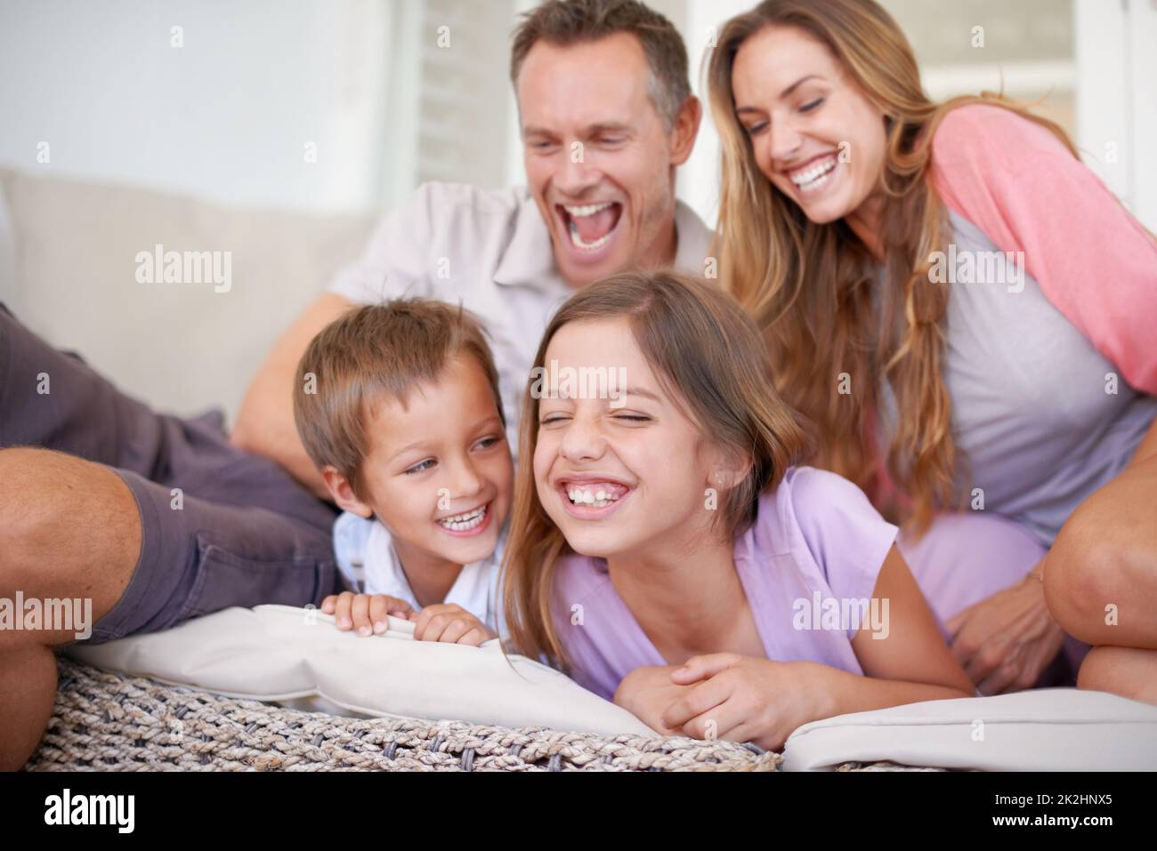 Attack of the tickle monsters. Shot of a happy young family playing together. Stock Photo