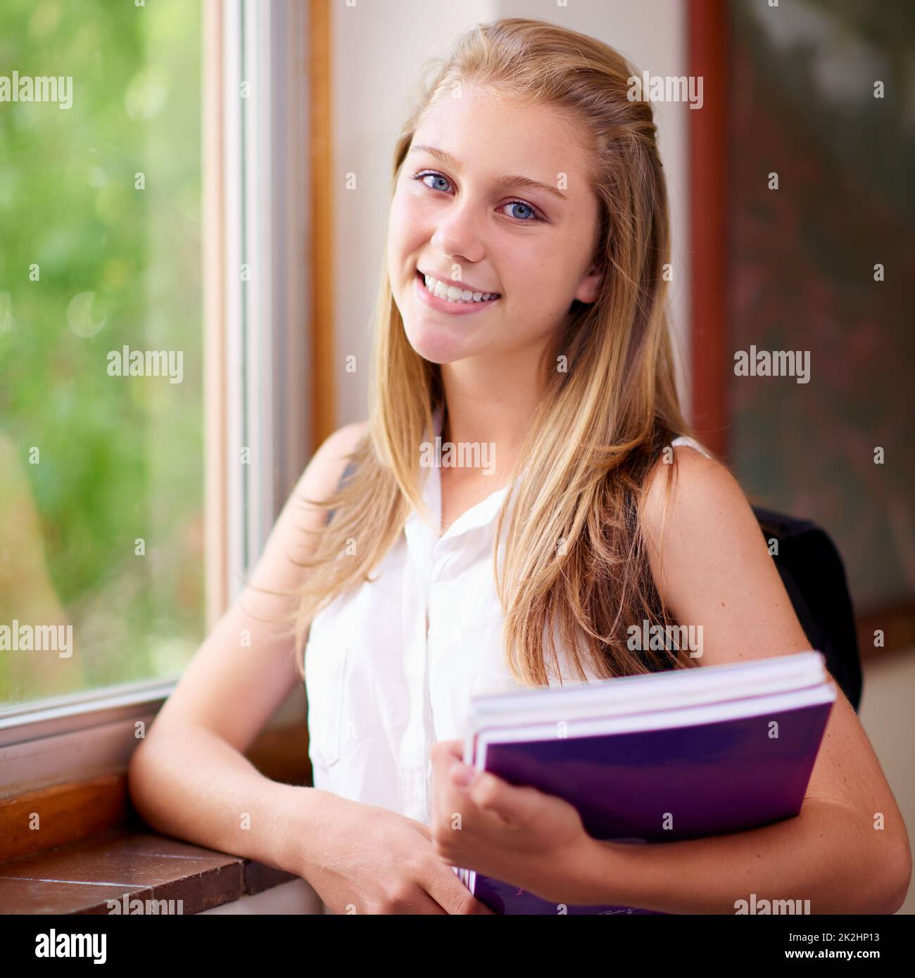 School is awesome. Shot of a young girl in her school hallway. Stock Photo