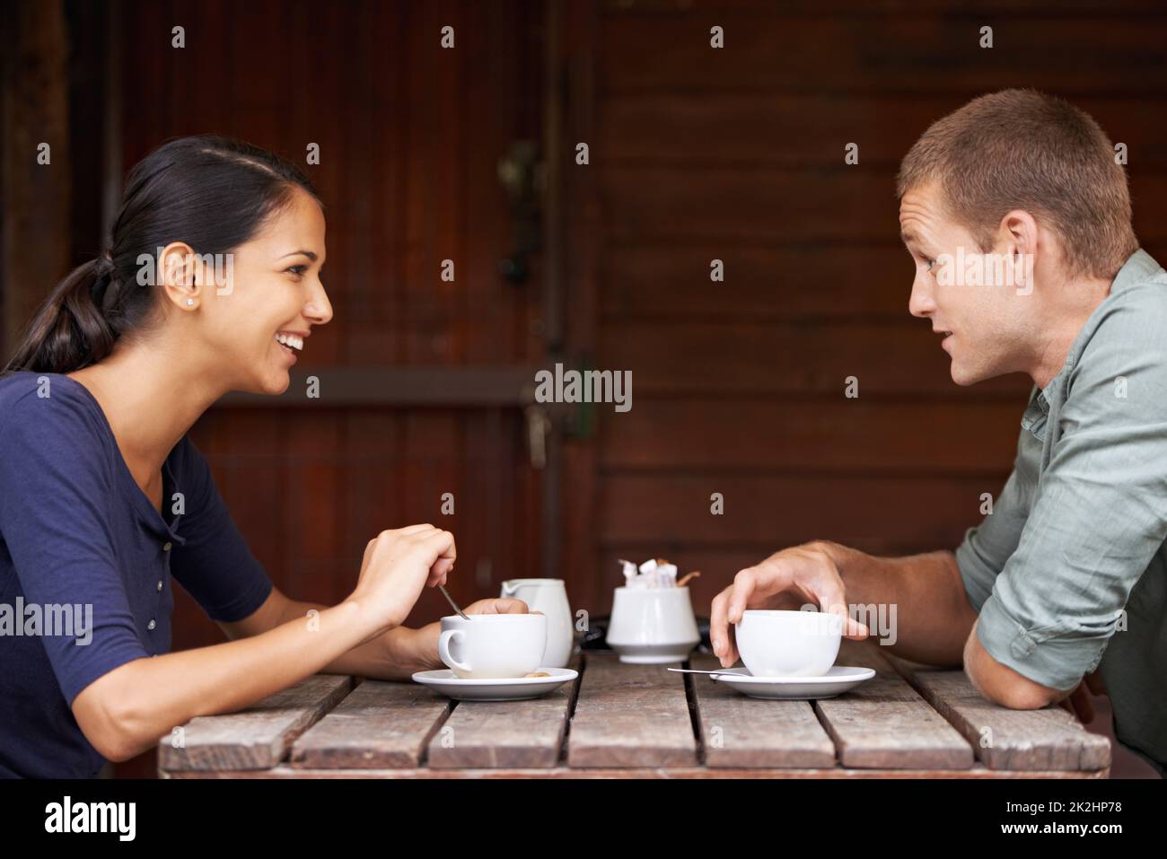 Is it cool if I hold your hand. Two young adults chatting over a cup of coffee. Stock Photo