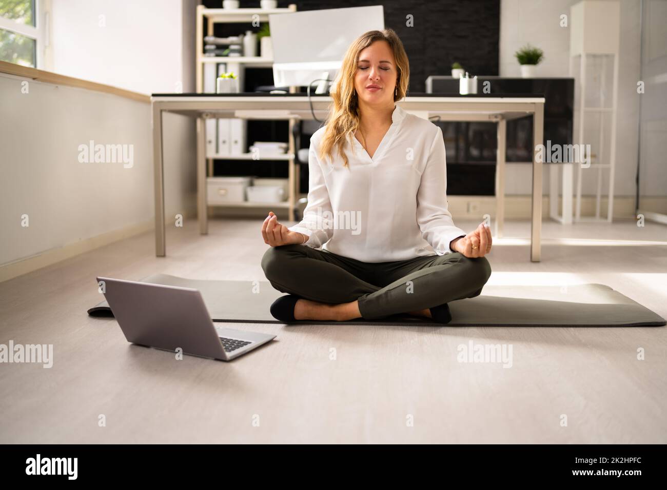 Employee Doing Mental Health Yoga Meditation In Office Stock Photo