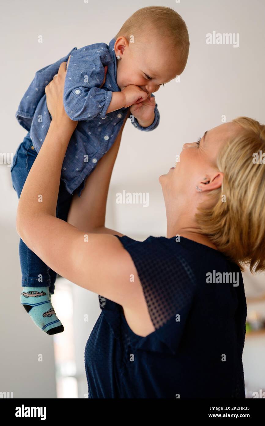 Family, child and parenthood concept. Happy smiling young mother with little baby at home Stock Photo