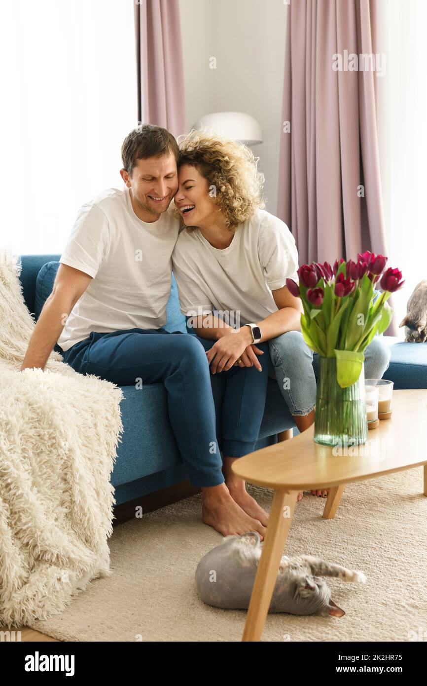 Happy caucasian couple and their cute cats at home Stock Photo