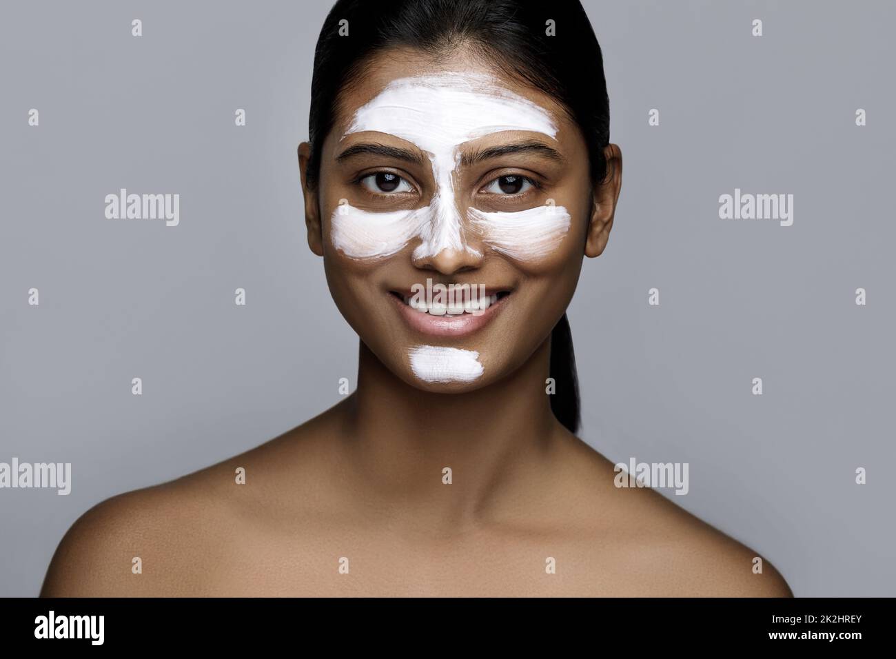 Young indian woman with a cleansing mask applied on her face Stock