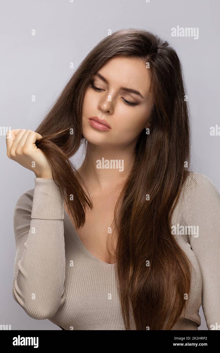 Young woman is upset with a bad condition of her hair Stock Photo