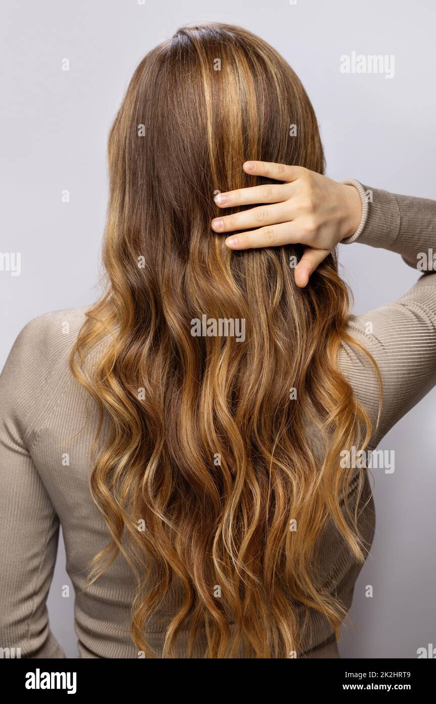 Young woman showing her beautiful hair after dyeing and styling Stock Photo