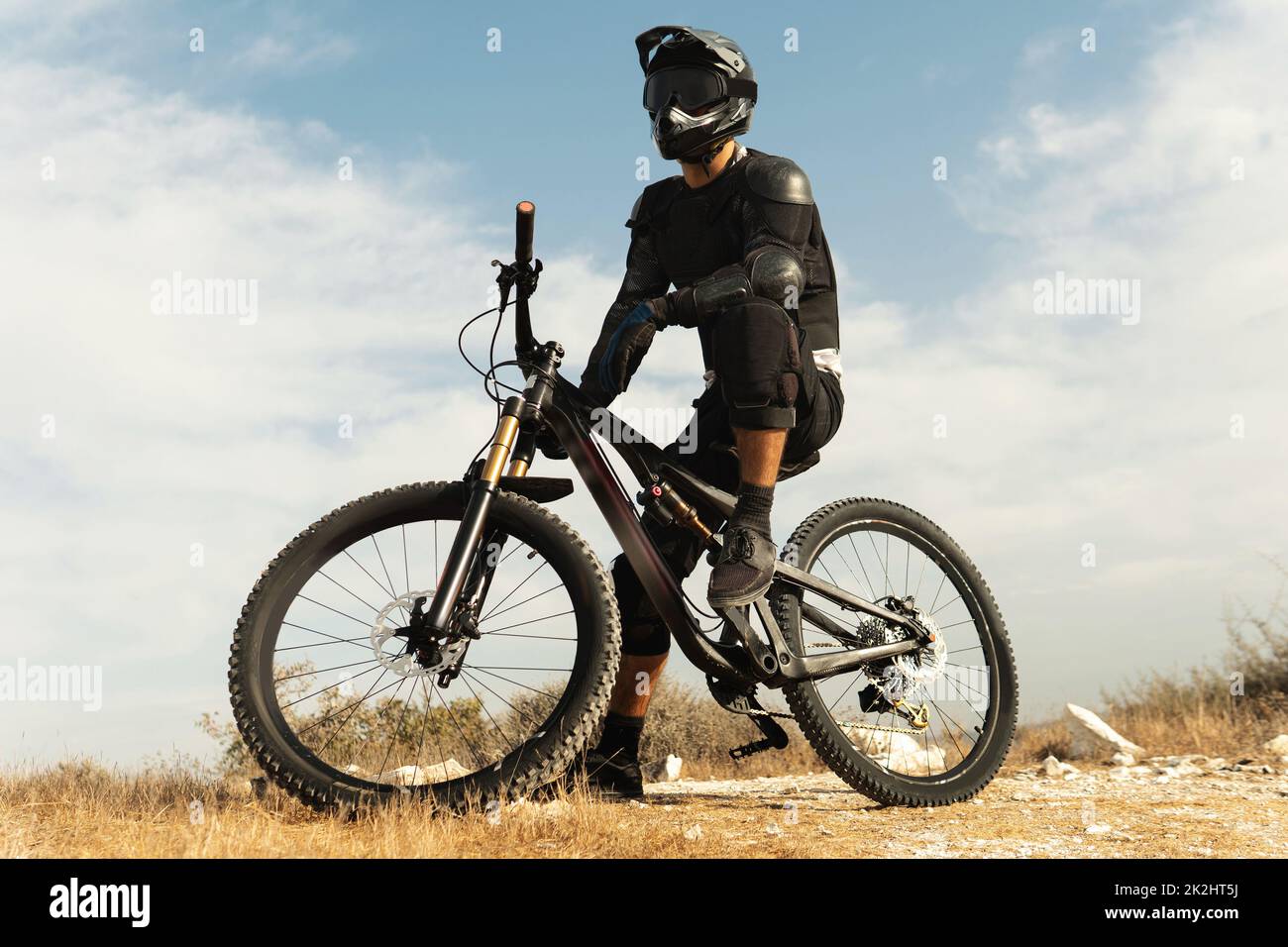 Downhill rider fully equipped with protective gear and his bicycle ...