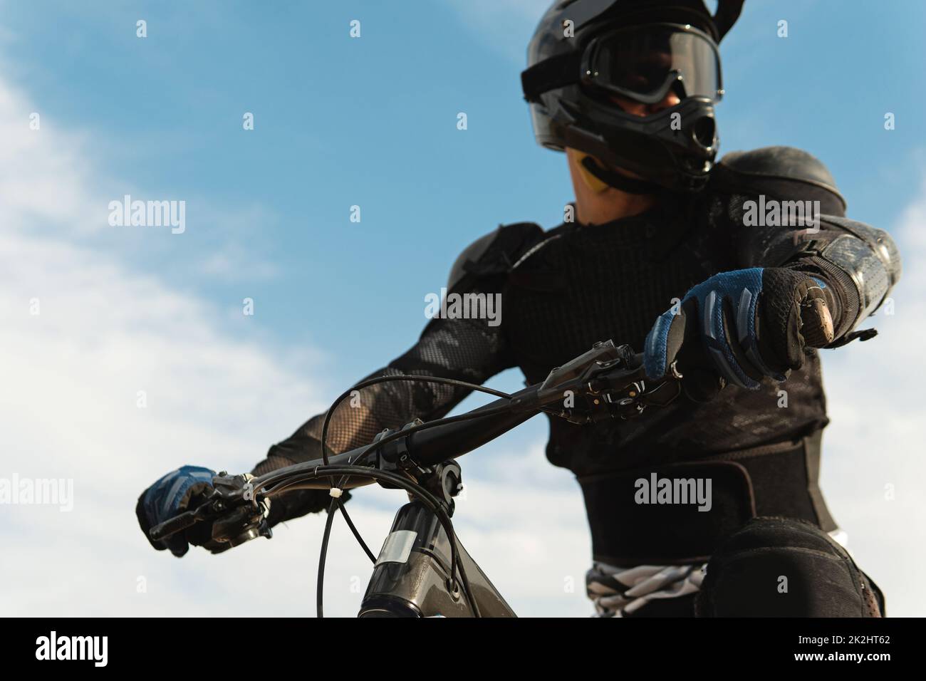 Downhill rider fully equipped with protective gear riding his bicycle