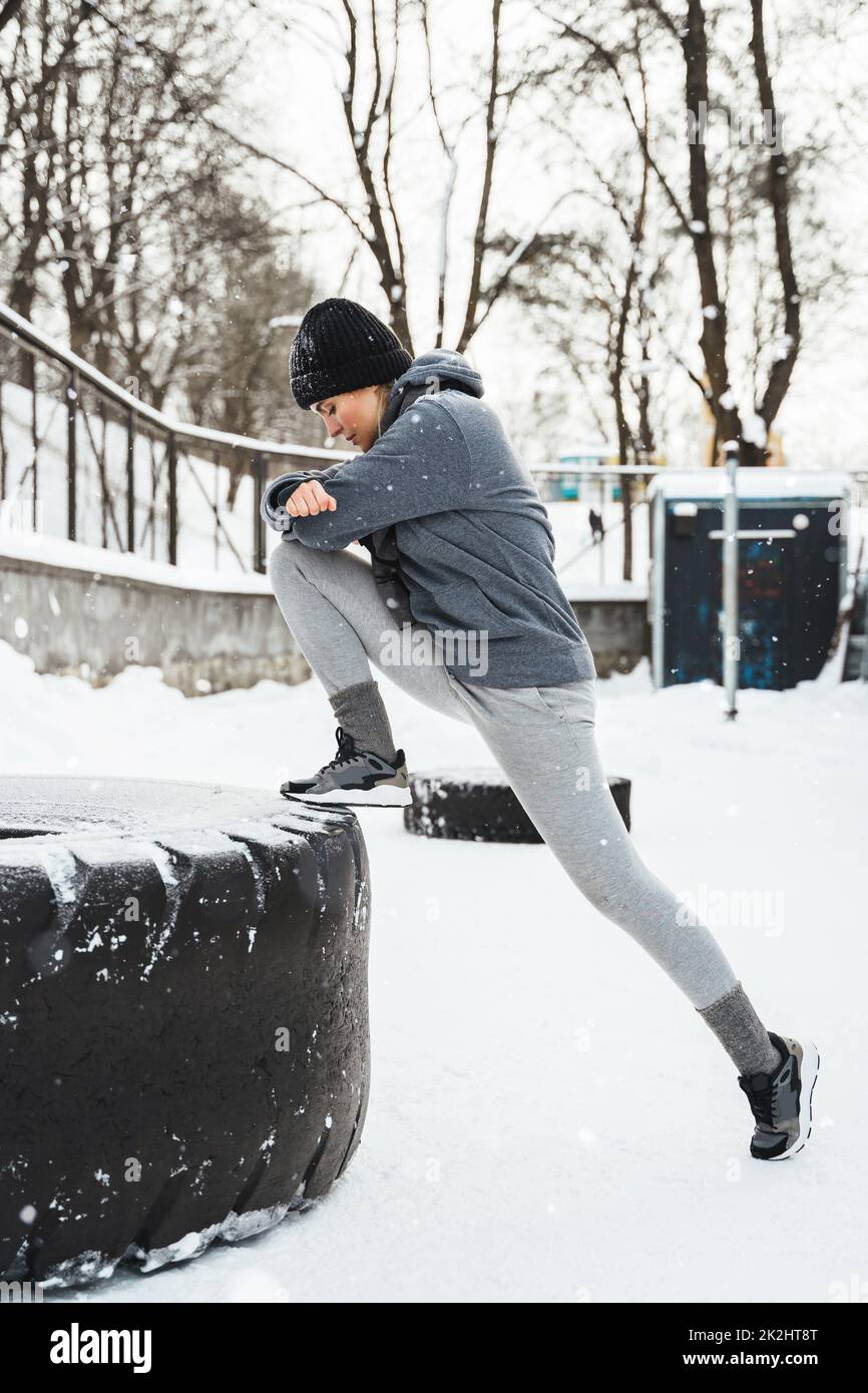 Athletic woman during her outdoors winter workout with a tire Stock Photo