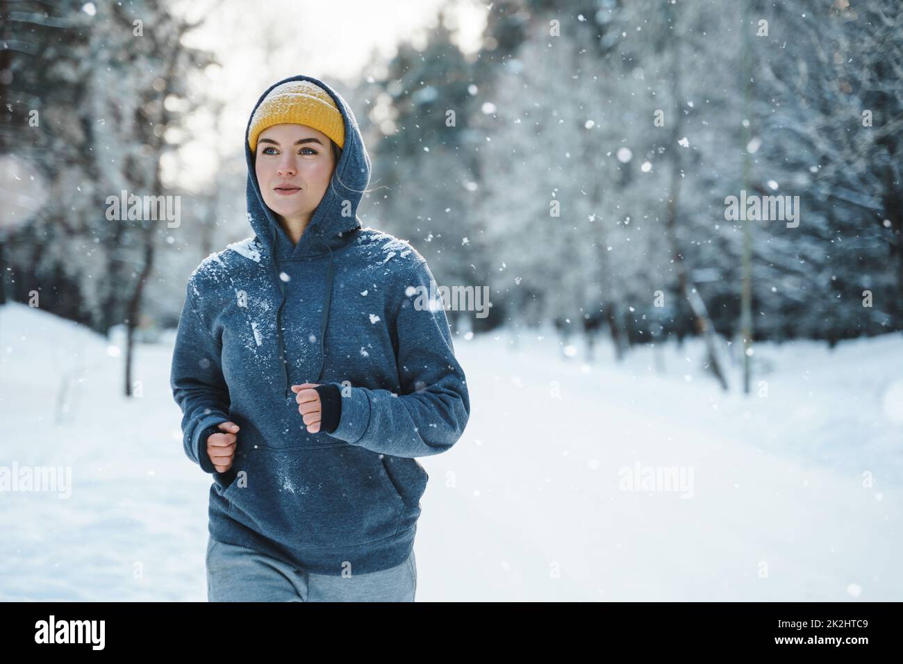 Woman during her jogging workout during winter and snowy day Stock Photo