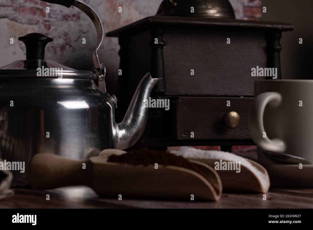 coffee cup with milk jug, coffee grinder and wooden spoons with sugar ground coffee Stock Photo