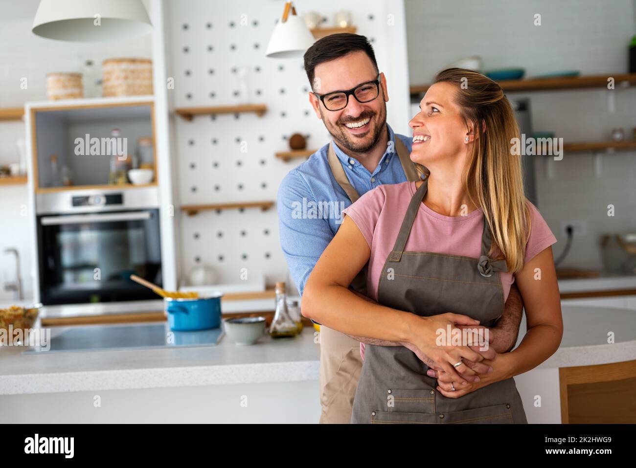 Attractive couple is cooking together organic healthy food in kitchen. Stock Photo