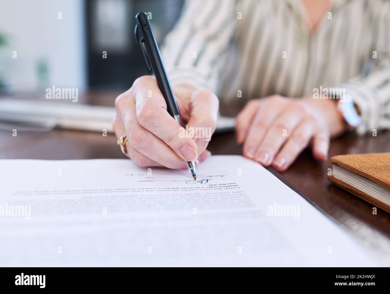 Signing off a new deal. Closeup shot of an unrecognisable businesswoman signing paperwork in an office. Stock Photo