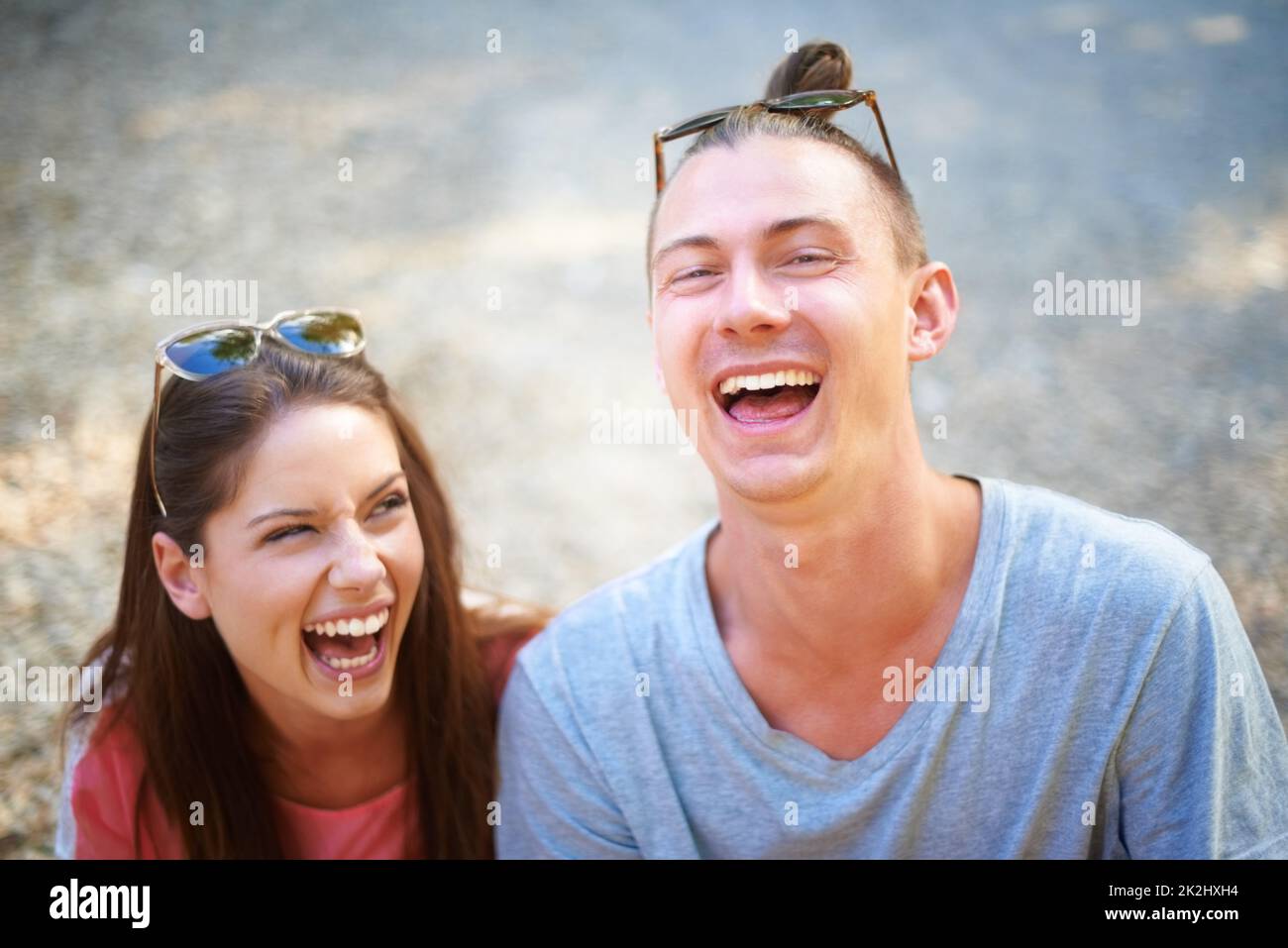 Young at heart. Two young people smiling happily as they sit outside. Stock Photo