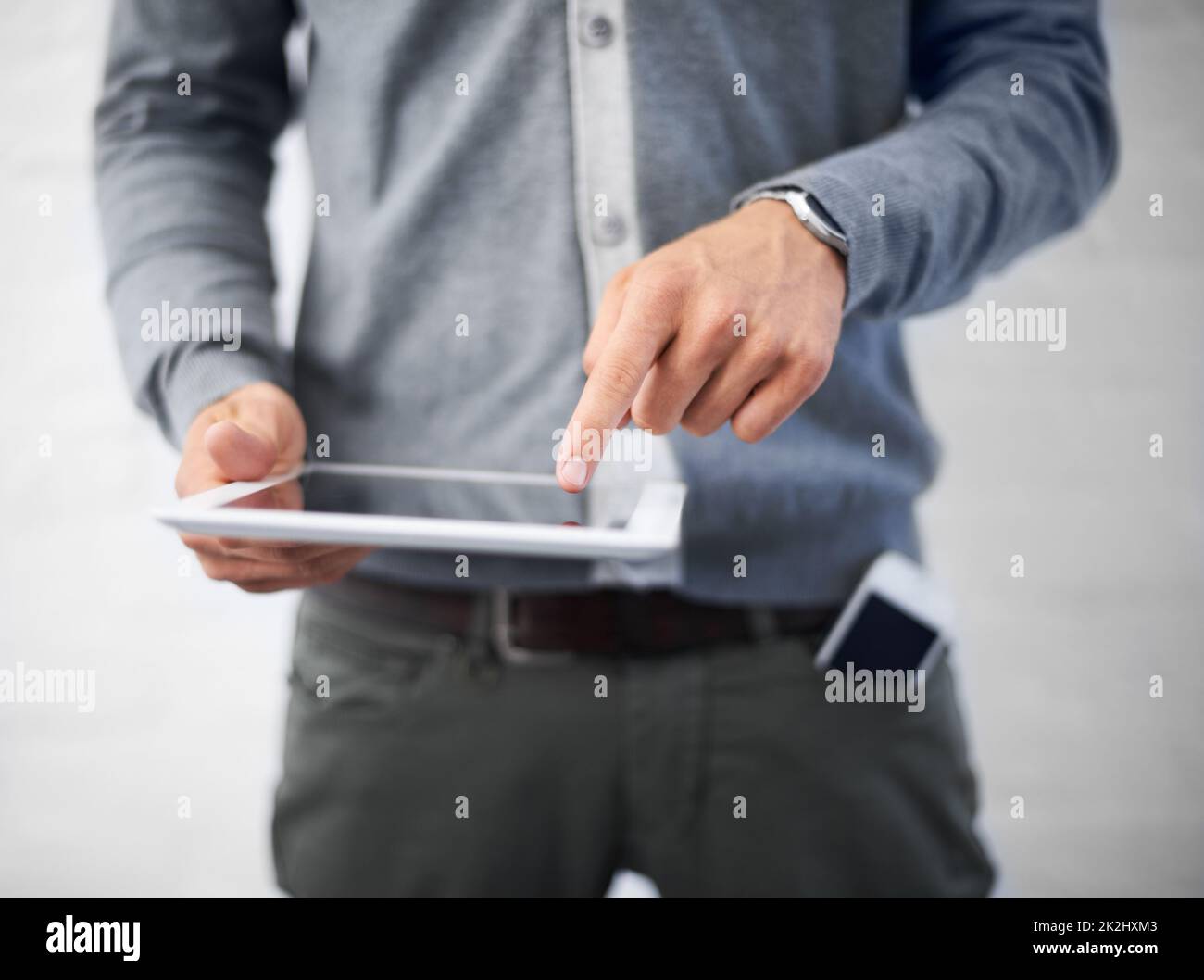 Managing his diary online. Cropped image of a young man working on his digital tablet. Stock Photo