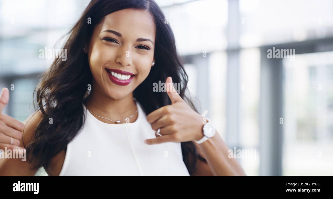 Business comes easy to me. Cropped shot of a young businesswoman showing thumbs up while walking through a modern office. Stock Photo