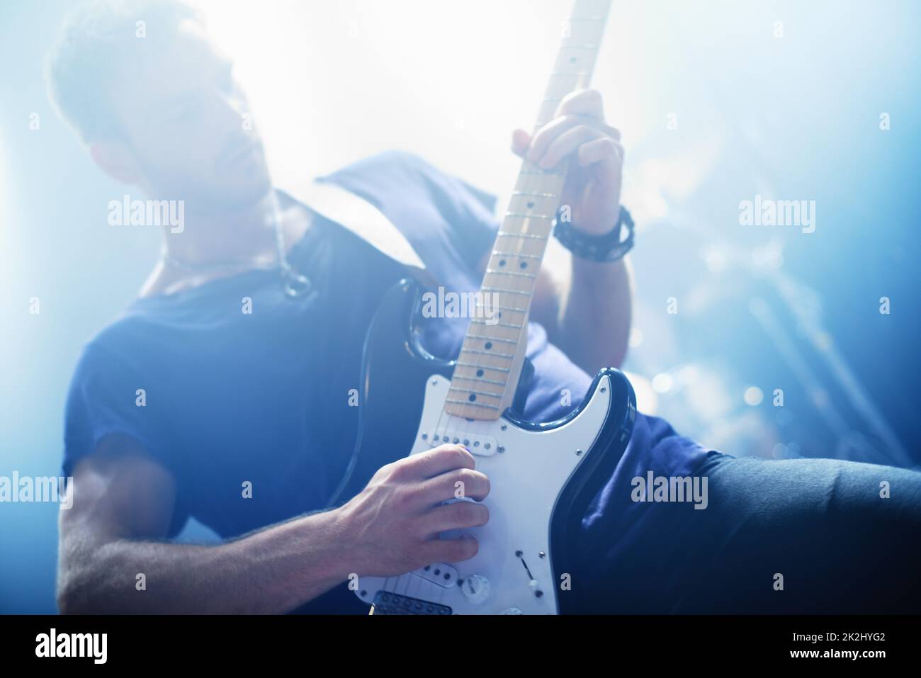 Making music. Cropped view of a rock star playing the guitar during a gig-This concert was created for the sole purpose of this photo shoot, featuring 300 models and 3 live bands. All people in this shoot are model released. Stock Photo