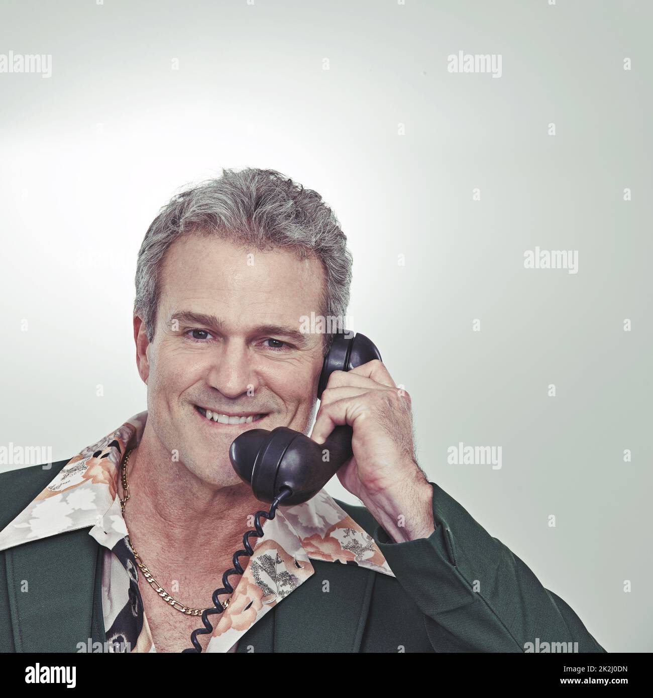 Give me a call, ladies. Cropped studio portrait of a confident mature man talking on an old-fashioned telephone. Stock Photo